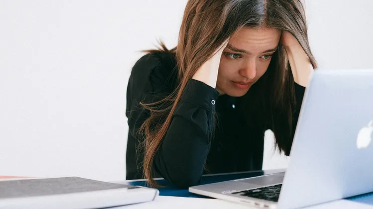 Mulher estressada olhando para um laptop — foto por Anna Shvets no Pexels